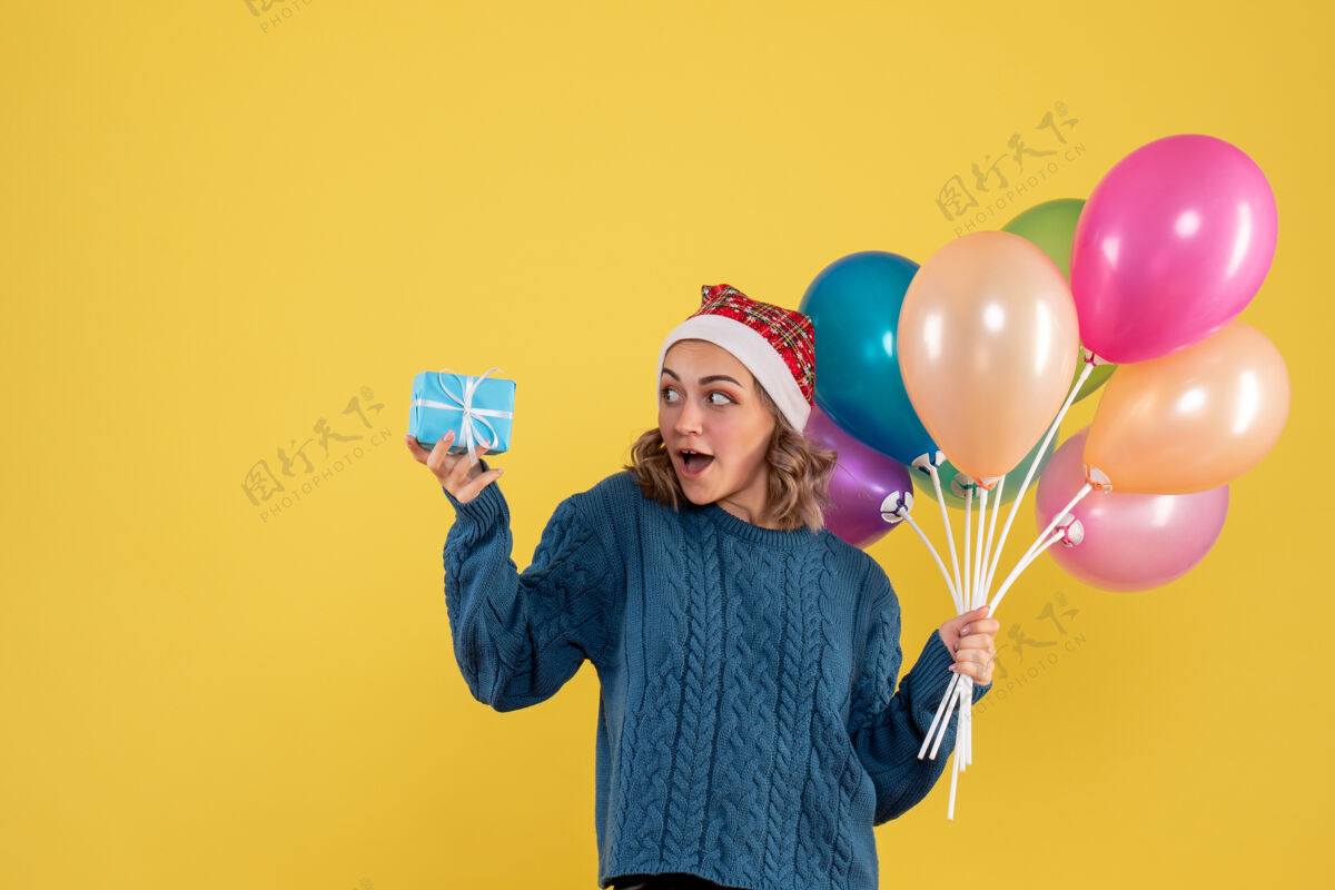 生日手持小礼物和黄色气球的年轻女性举行聚会气球