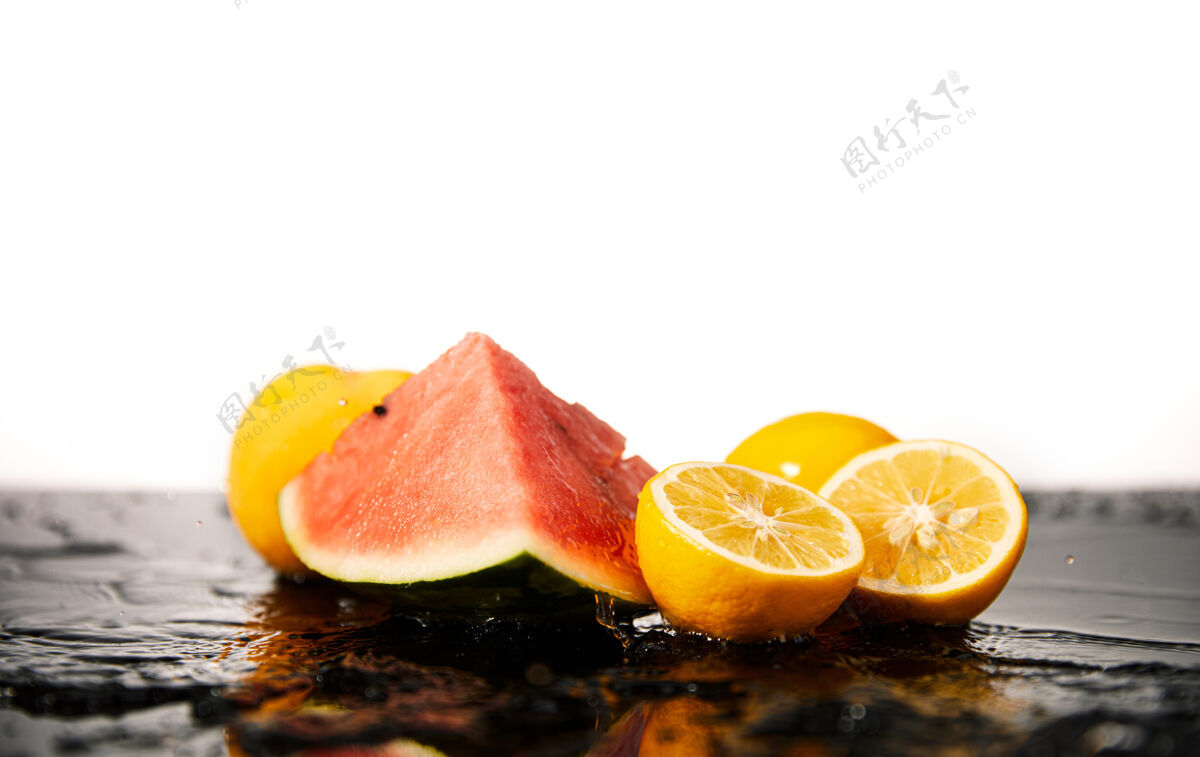 成熟西瓜和橙子在潮湿表面的选择性聚焦拍摄新鲜西瓜柑橘