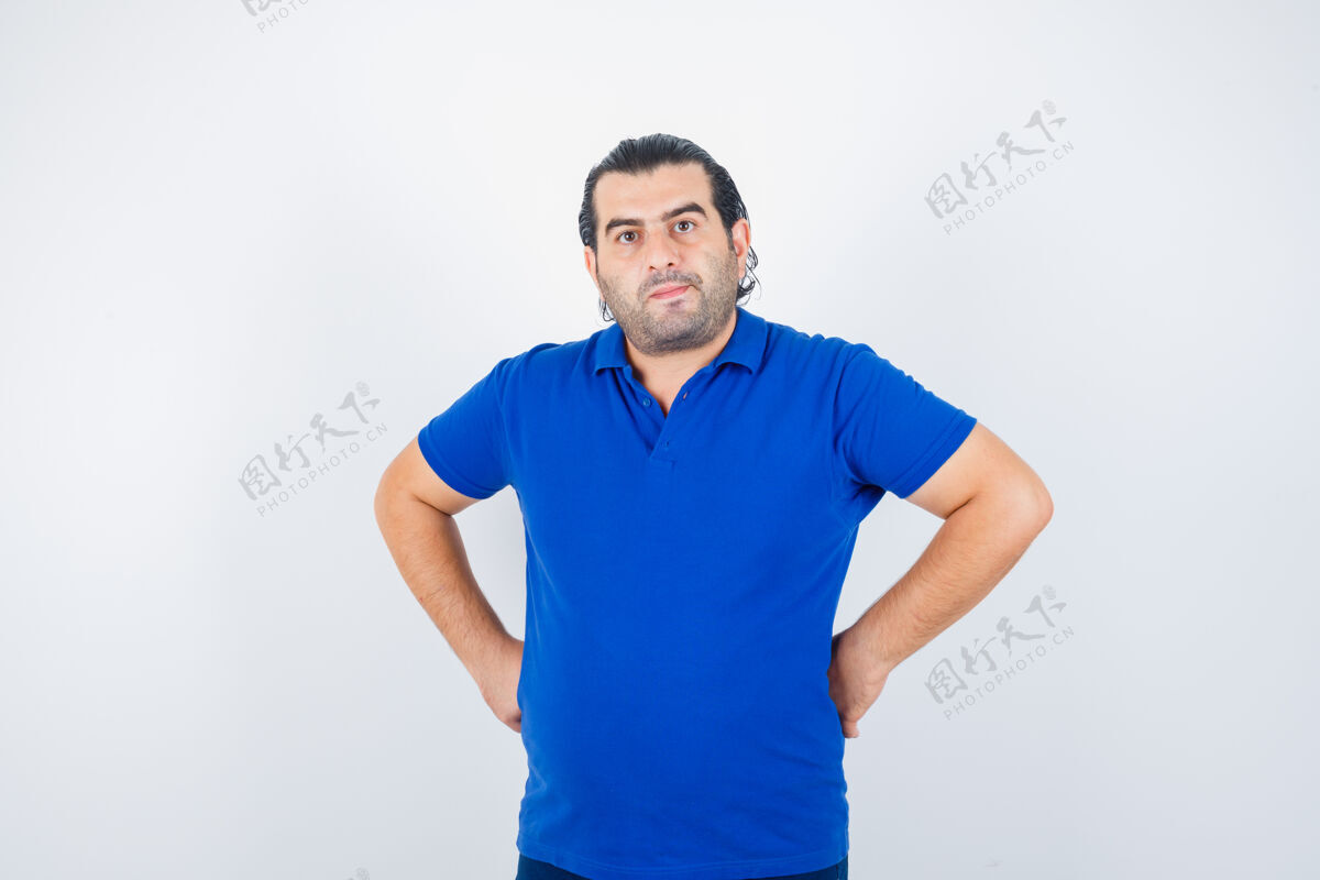 成人中年男子身穿蓝色t恤 双手放在臀部 看上去自信满满自信商业优雅