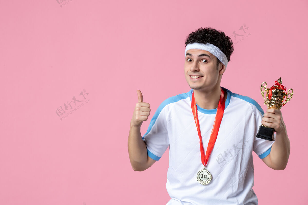 粉色正面图身穿运动服的年轻球员 粉色墙上挂着金杯奖项胜利金色