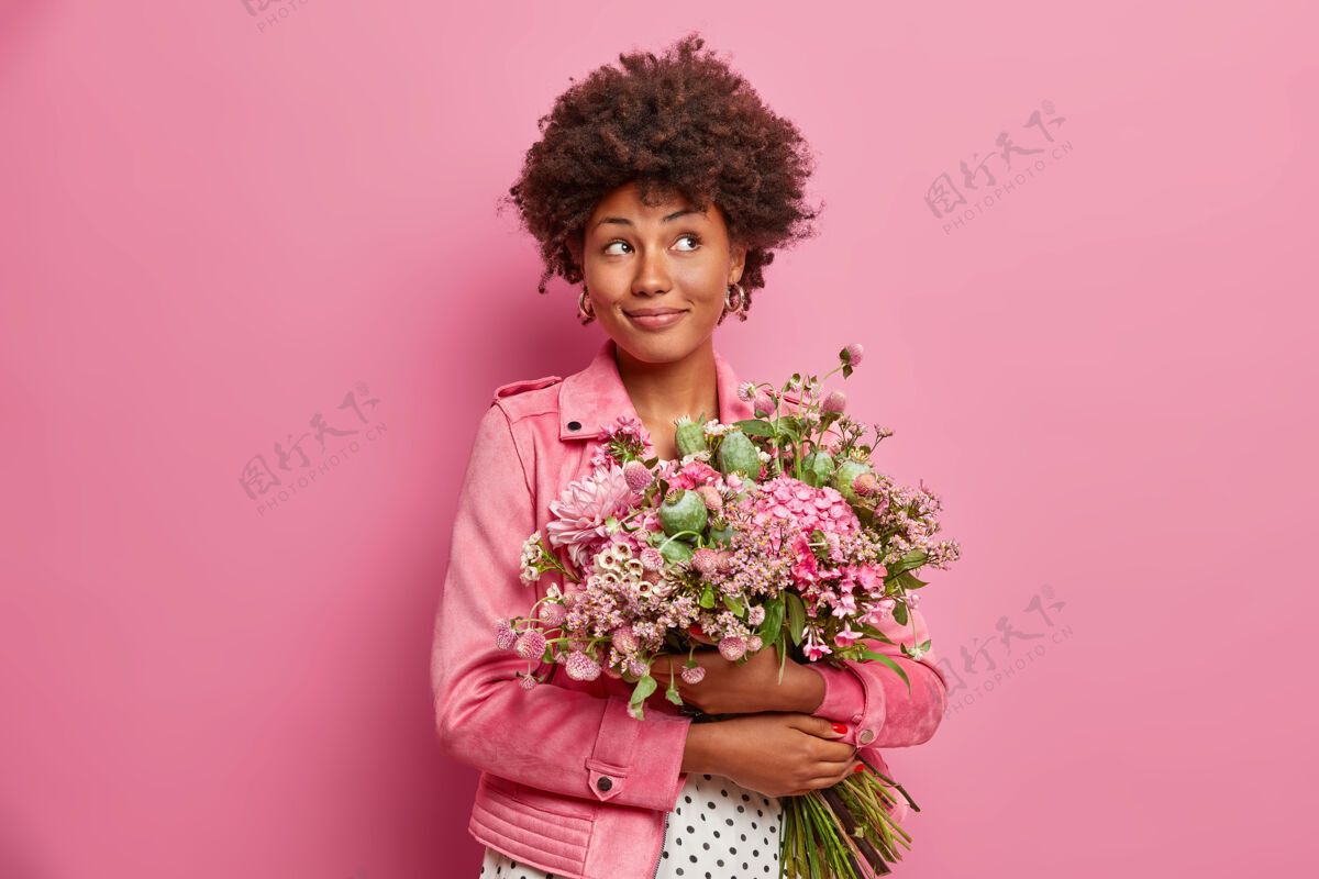 举行沉思的美国黑人妇女 带着美丽的花束 穿着时髦的衣服 凝视风格场合