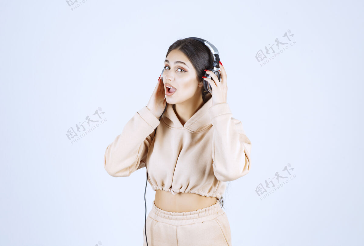 音乐年轻女子戴着耳机 愉快地听着她的播放列表休闲姿势工人
