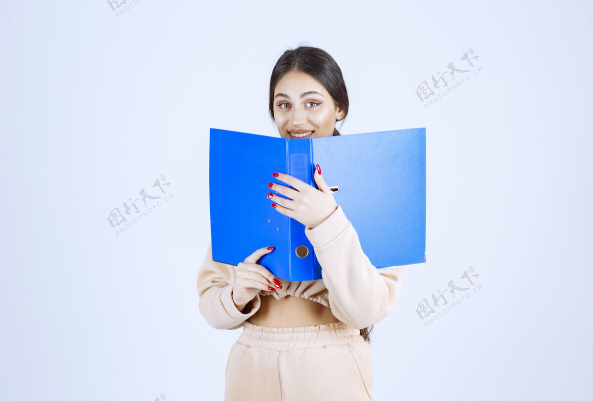 成人新来的助手把脸藏在蓝色文件夹后面女人模特姿势