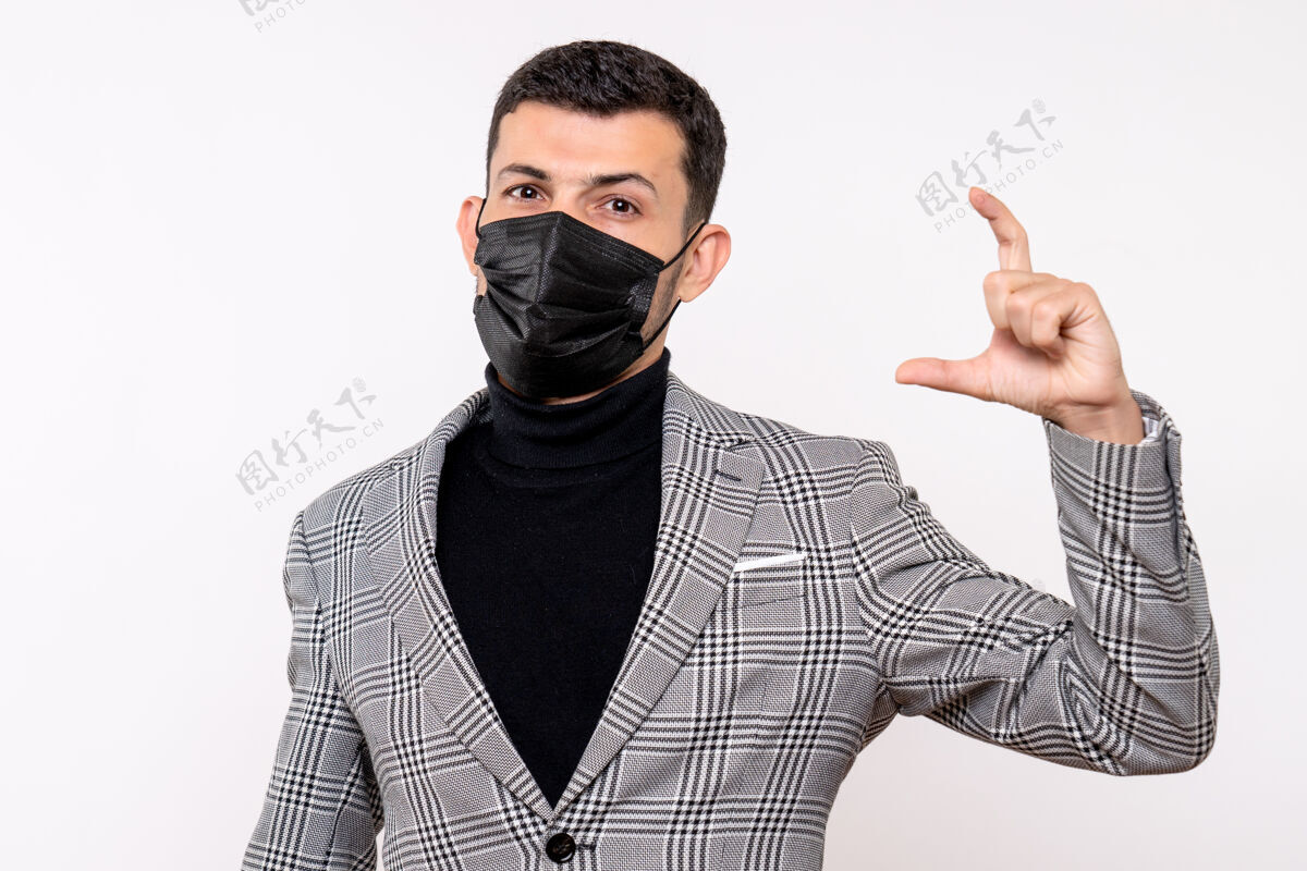 专业正面图：戴着黑色面具的年轻人 手指站在白色孤立的背景上 显示出他的身材人男性西装