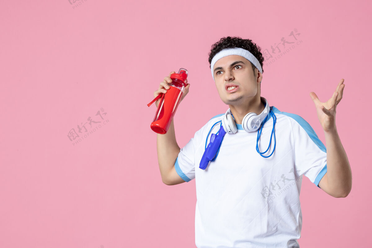 视图正面图穿着运动服的男运动员拿着一瓶水锻炼运动前面