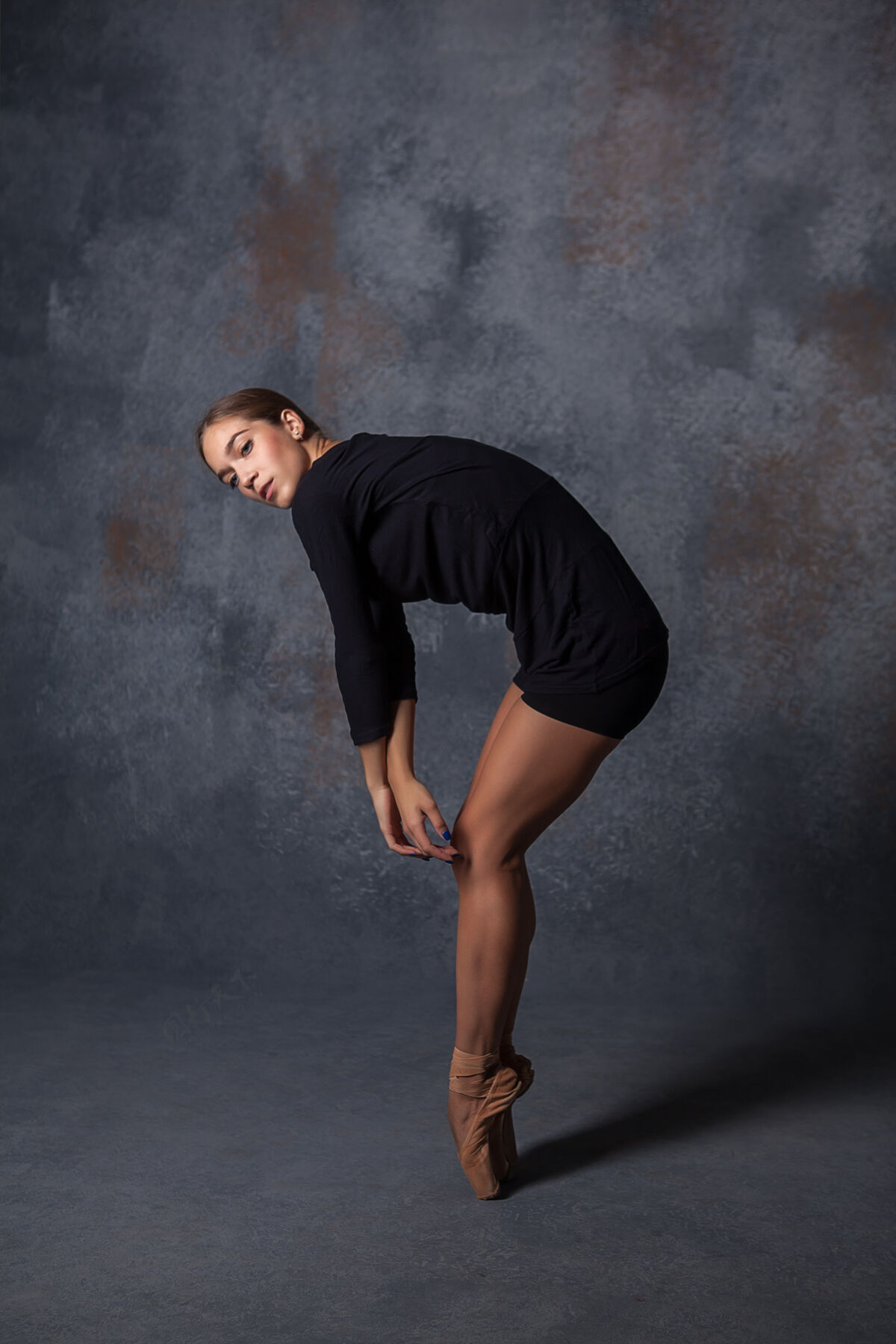 女孩年轻漂亮的现代风格舞者在灰色背景上摆姿势动作平衡身体
