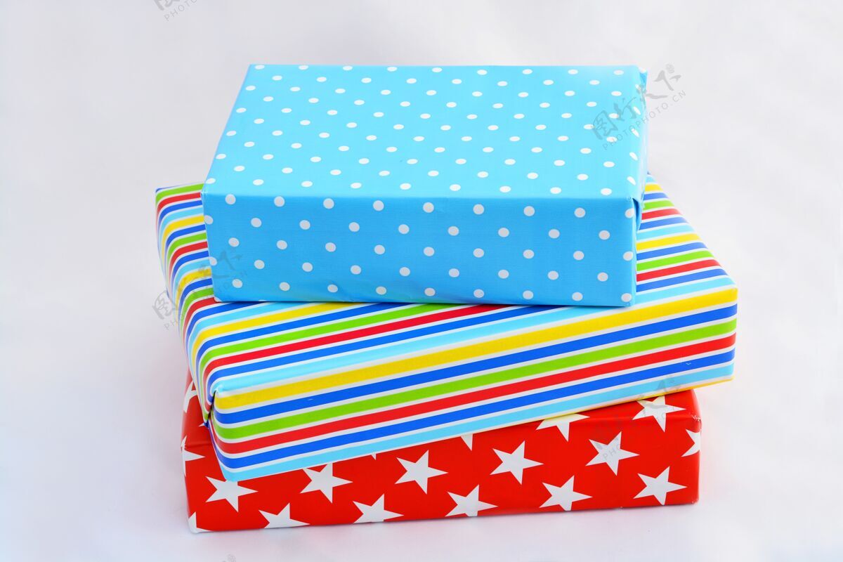 圣诞节孤立的特写镜头的礼品盒在彩色包装堆叠在每个白色背景上的顶部包装年鲜花