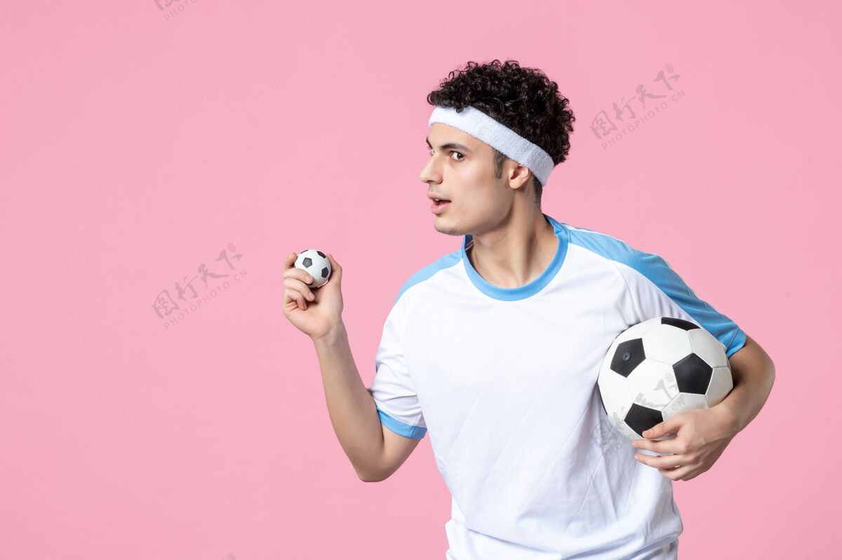 足球运动员前视图穿着运动服的足球运动员拿着球体育人球