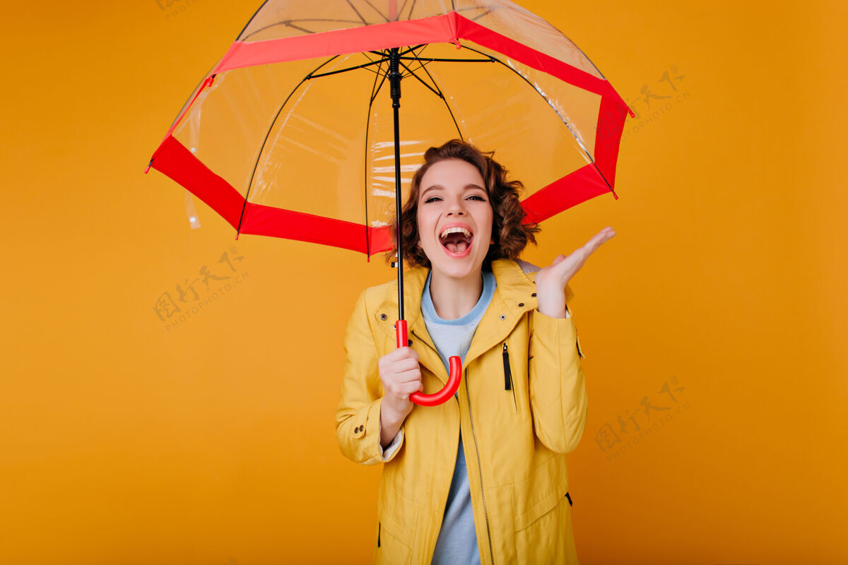 明亮穿着黄色秋衣的迷人女人 表达积极的情感优雅的卷发女孩在伞下欢笑黑发情绪肖像