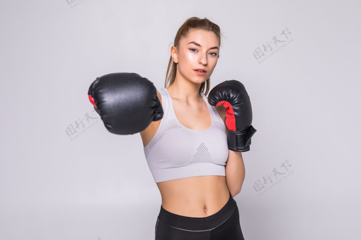 赛车一个年轻女子拳击手在练习时向前面扔拳的画像手套拳击手人