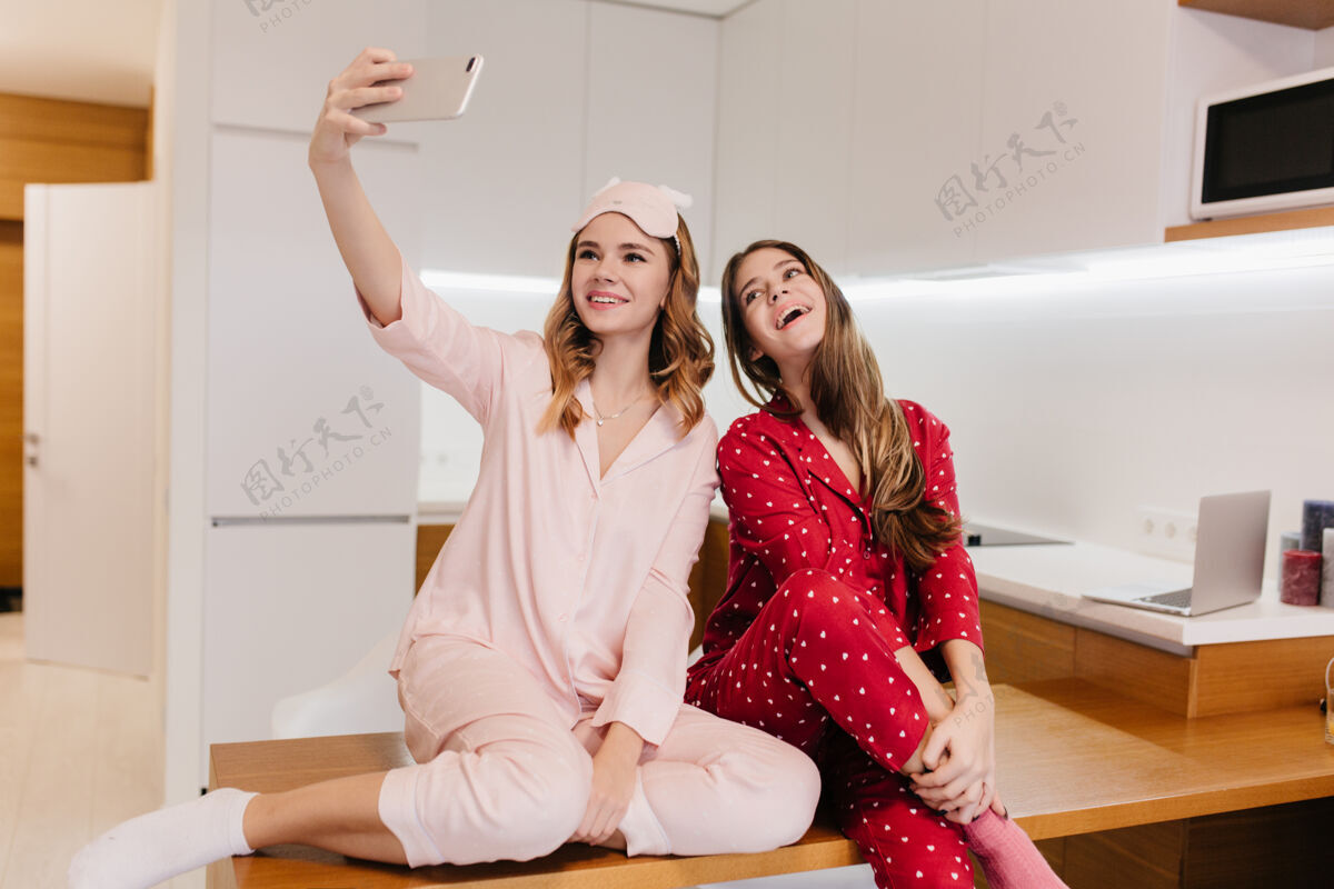 放松令人愉快的欧洲女孩在早餐前自拍漂亮的金发年轻女子在厨房用手机拍照的室内照片幸福朋友自拍