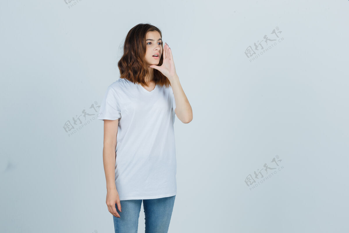 青年一个穿着白色t恤 牛仔裤 看起来很可爱的年轻女孩对着别人大喊大叫头发女人年轻
