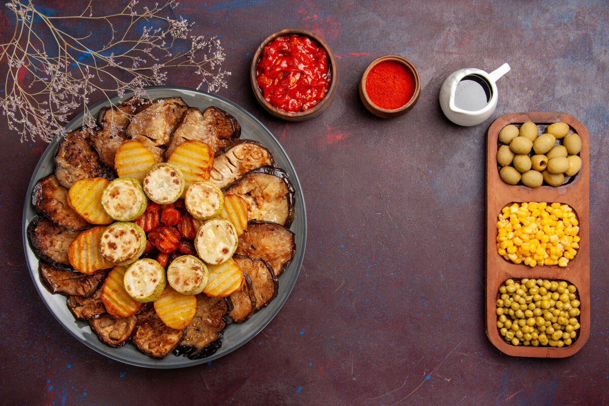 盘子俯瞰美味的烤蔬菜土豆和茄子在黑暗的背景下烤箱烹饪烤蔬菜晚餐美味景观