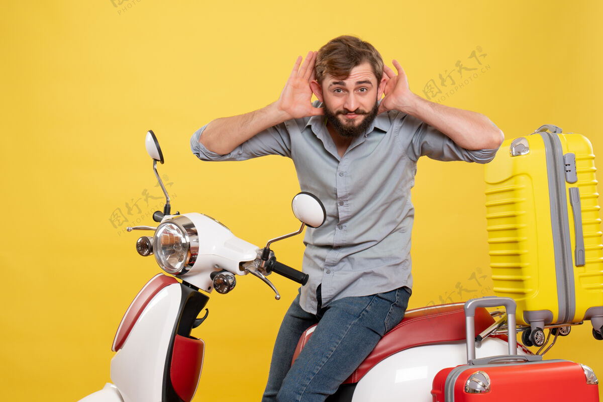 旅行旅游概念与年轻的情感胡须男子坐在摩托车上 听它的最后八卦黄色运动装置摩托车传送带