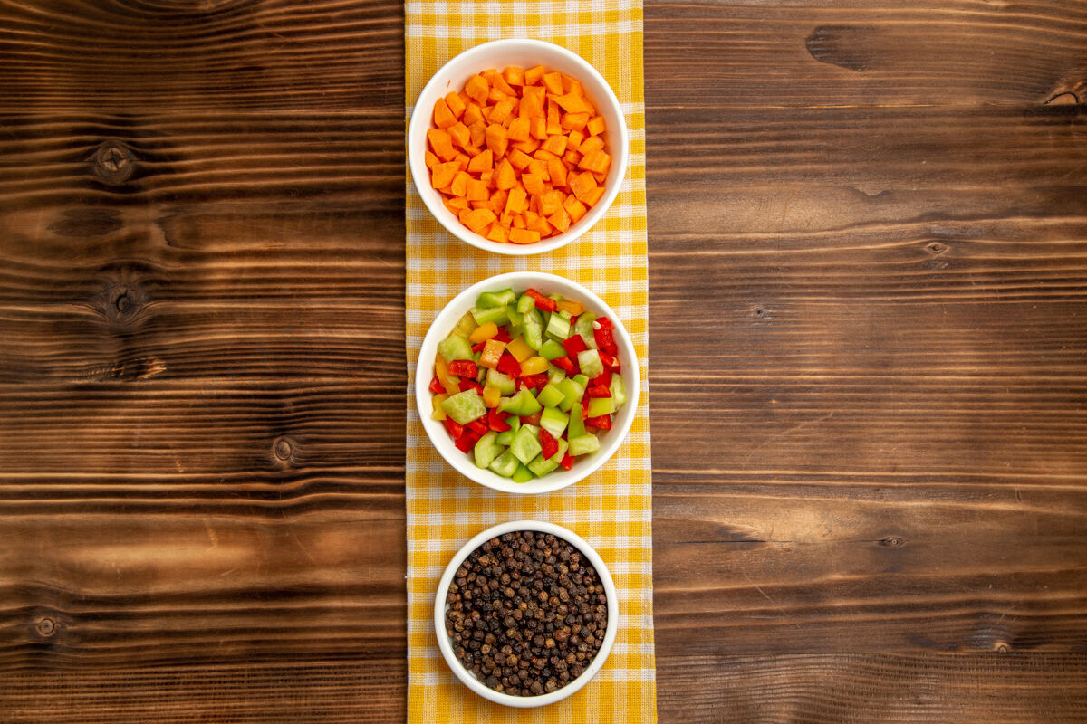 生的顶视图棕色木桌上的甜椒切片和调味料蔬菜餐食品健康沙拉蔬菜餐馆食物