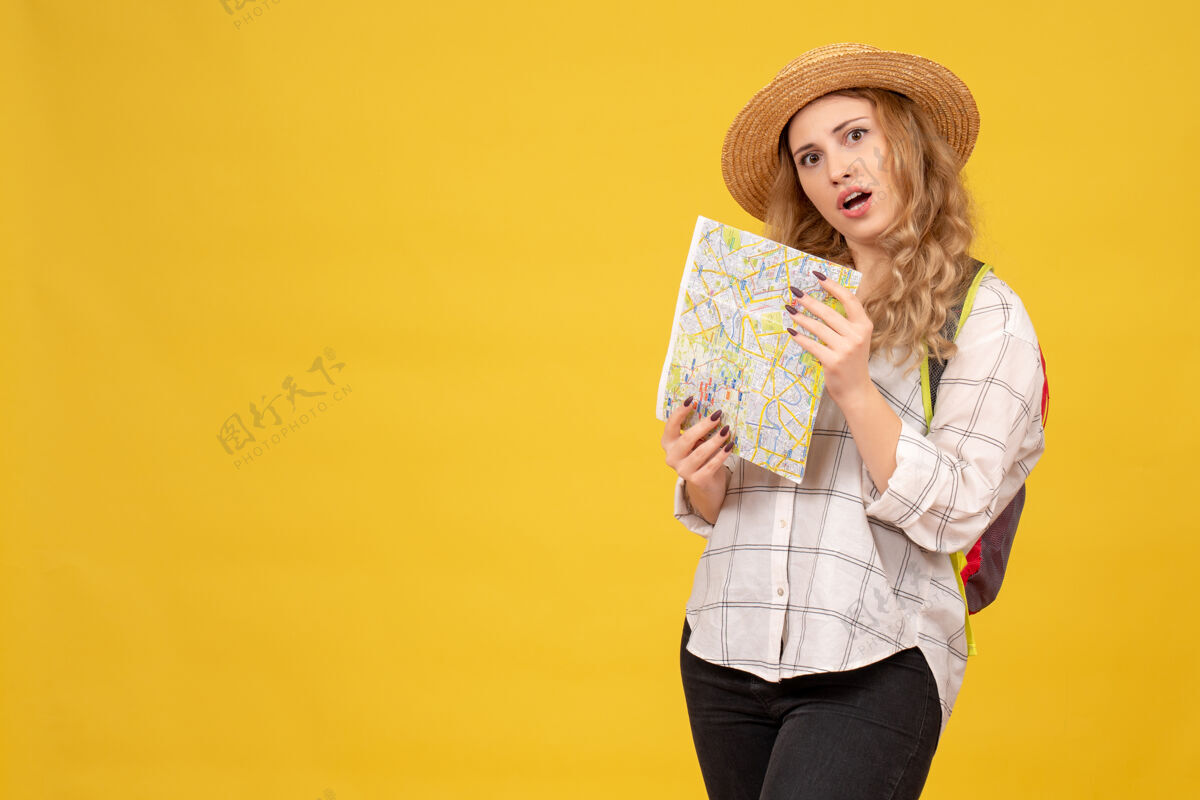 成人顶视图混乱的旅行女孩戴着她的帽子和背包举行黄色地图帽子地图漂亮