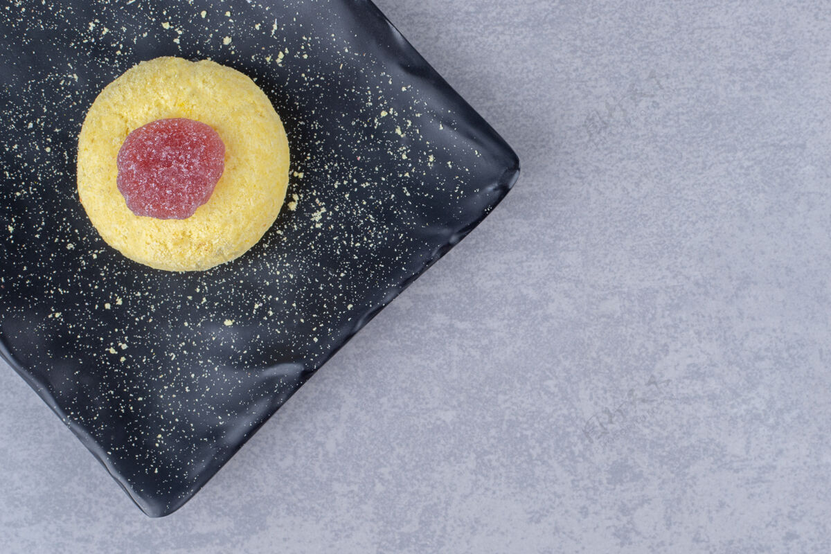 拼盘饼干和果酱放在大理石上的黑色盘子里美味美味甜点
