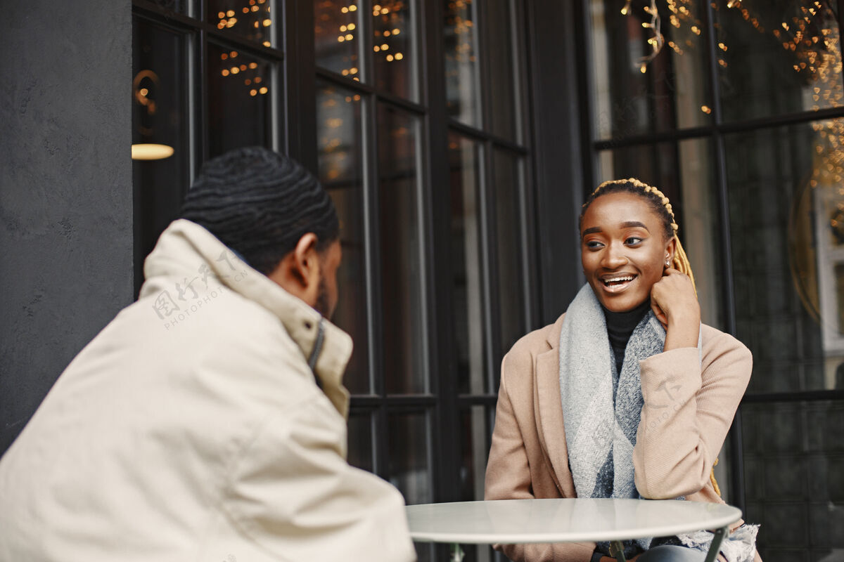 美国两个年轻人坐在外面一对非洲夫妇享受着与对方共度的时光男性非洲女性