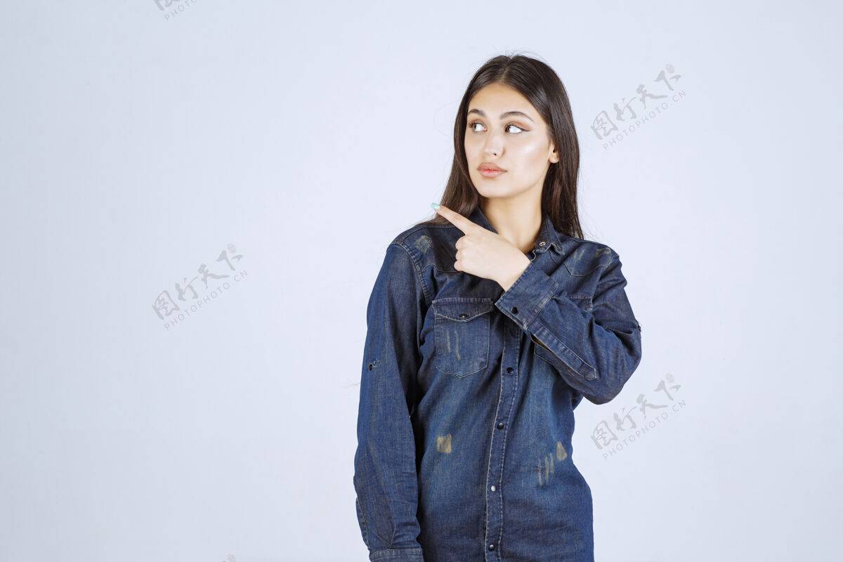 年轻人穿牛仔衫的年轻女子指着左边成人目的地年轻