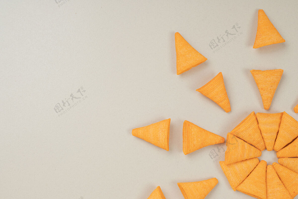 食物灰色表面上的三角形碎片可口薯条三角饼