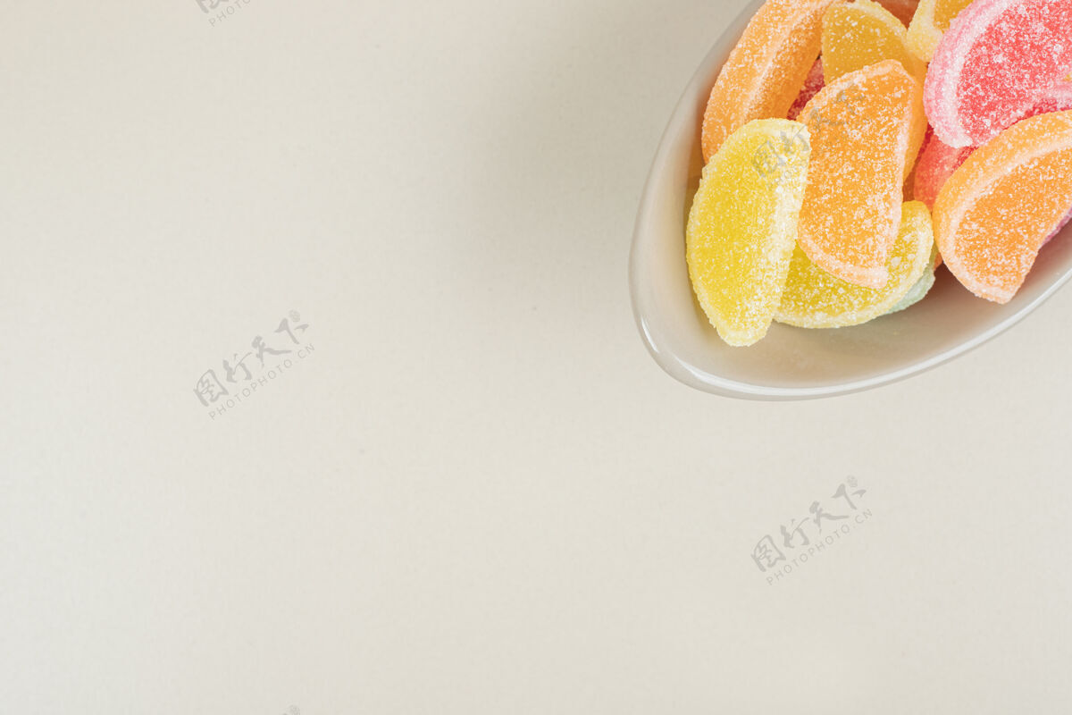 零食甜甜的彩色果冻糖果在米色的碗表面五颜六色邦邦切片