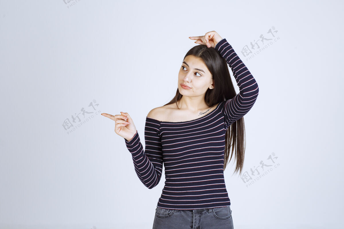 人体模型穿条纹衬衫的女孩指着旁边年轻休闲服装