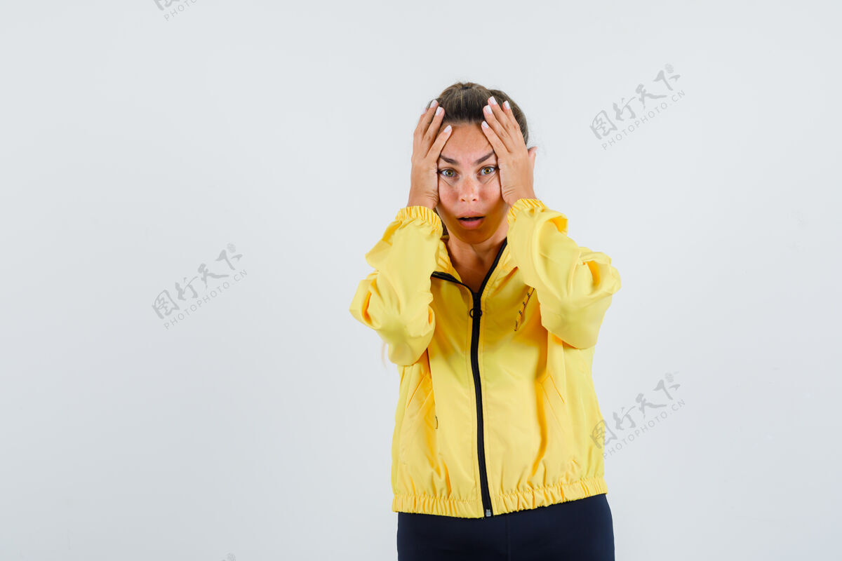 美丽一个年轻的女人手拉着手 头上穿着黄色雨衣 看起来很不安举行爱快乐