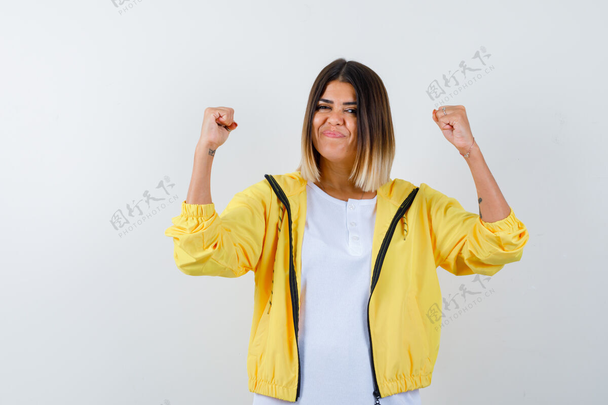 金发身穿白色t恤 黄色夹克 看上去很幸运的年轻女孩展示了赢家的姿态惊喜头发夹克