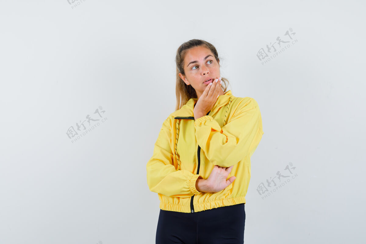 东西一个金发女人 下巴靠在手掌上 一边想着穿着黄色棒球服和黑色裤子的东西 一边沉思着年轻脸金发