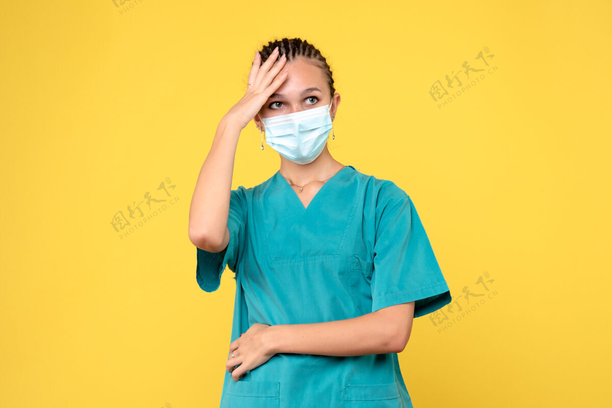 黄色正面图女医生穿着医用衬衫 戴着口罩 健康护士医院病毒covid-19大流行医院女性肖像