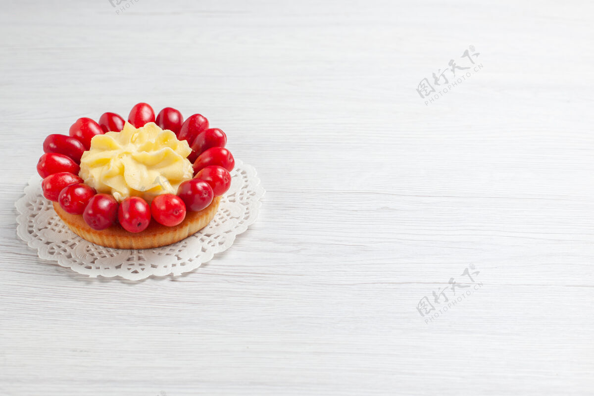 可食用水果前视图小奶油蛋糕与山茱萸在白色办公桌奶油水果色蛋糕甜点浆果葡萄干水果