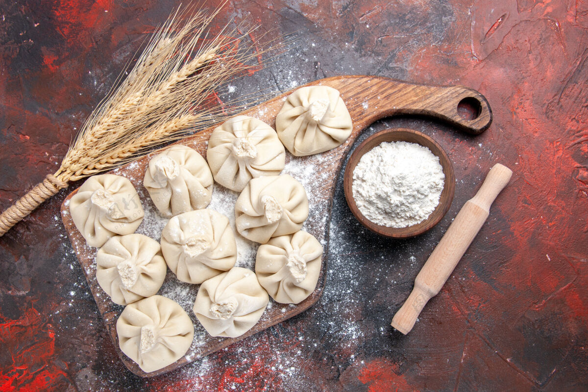 Khinkali顶部特写镜头：切菜板上的十根麦穗面粉擀面杖卷小麦面粉