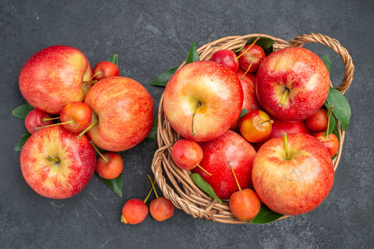 多汁顶部特写查看水果红黄色的苹果和浆果 篮子里有叶子篮子新鲜叶子