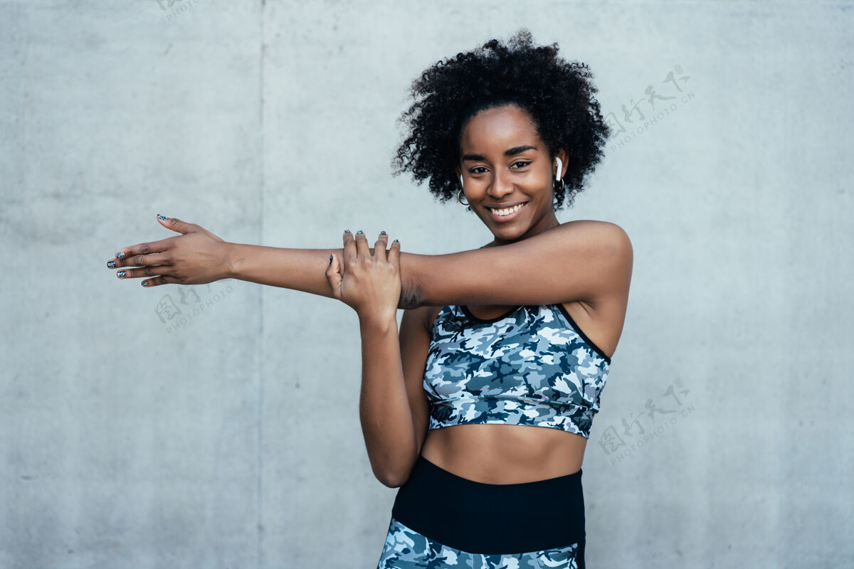 健身房一位非洲运动妇女在户外运动前伸展双臂热身肖像成人黑人