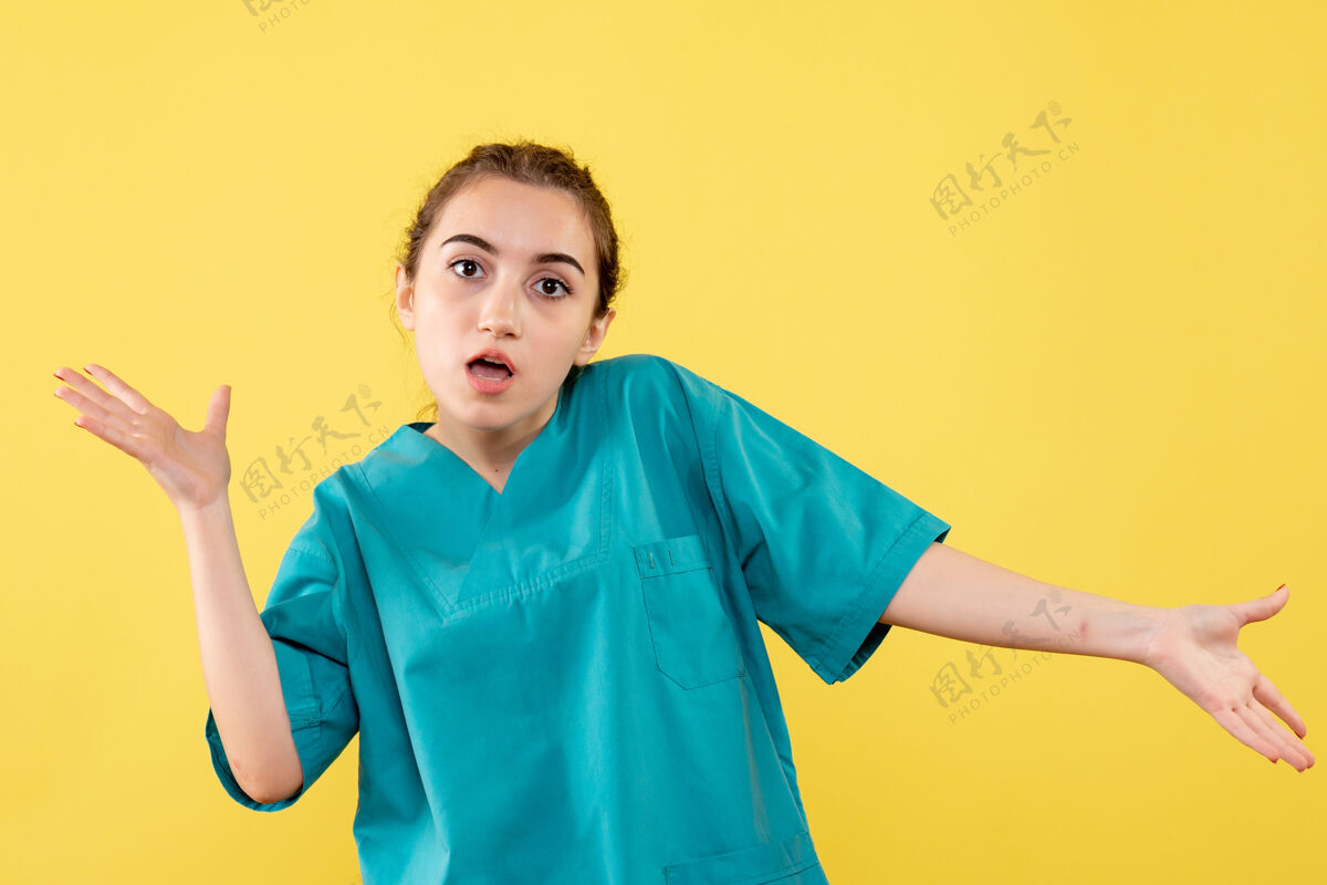 前面黄墙上年轻女医生穿着医用衬衫的正面图护士快乐医疗