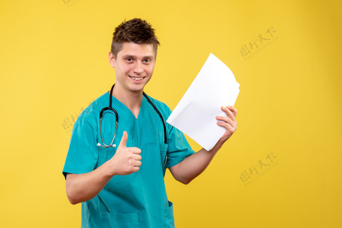 男医生黄色墙壁上的男医生穿着医疗服的前视图和分析医生医院情绪