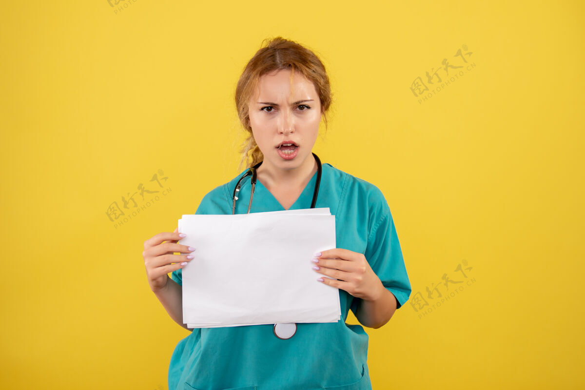护士黄墙上穿着医疗服的女医生手持分析图女医生病毒快乐