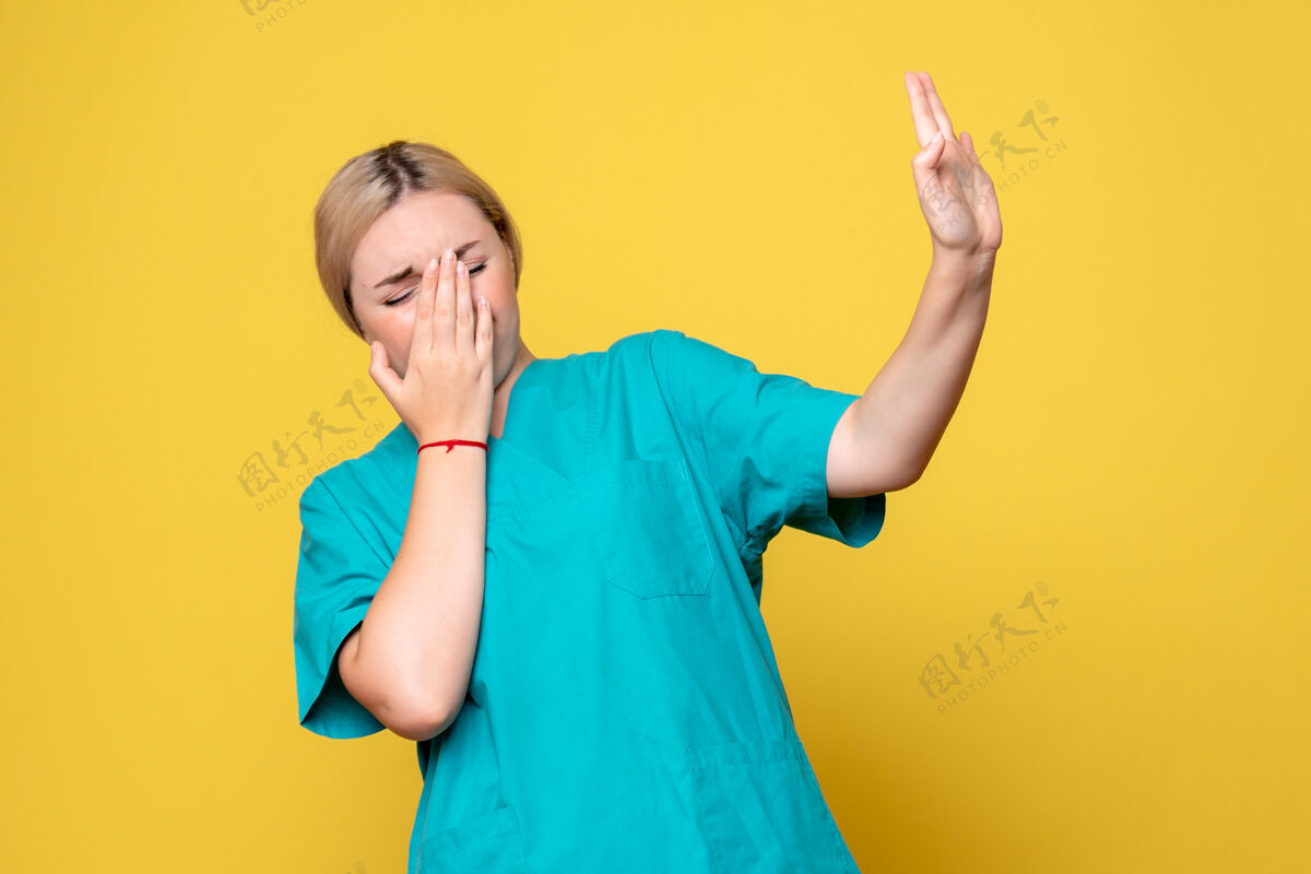 快乐黄墙上年轻女医生穿着医用衬衫的正面图护士成功情绪