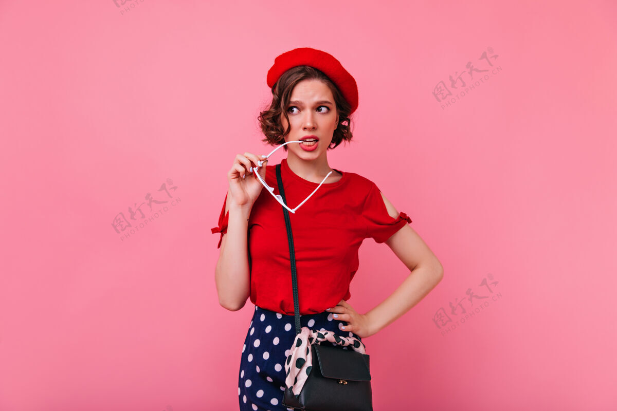 情感忧心忡忡的法国女人摆姿势高加索卷发女孩戴红色贝雷帽配件搞笑成人