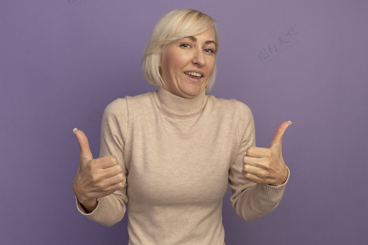 漂亮快乐美丽的金发斯拉夫女人竖起大拇指的两只手上的紫色时尚拇指欢乐