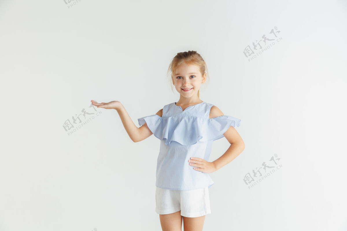 小时尚的微笑小女孩 穿着休闲服 在白色的工作室背景下摆姿势白人金发女模特人类的情感 面部表情 童年展现一个空荡荡的空间休闲学校孩子