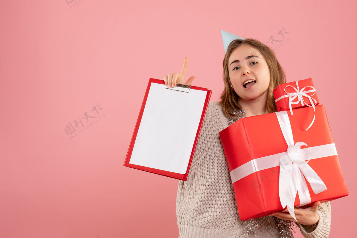 礼物正面图年轻女性手持圣诞礼物和纸条举办便条礼物