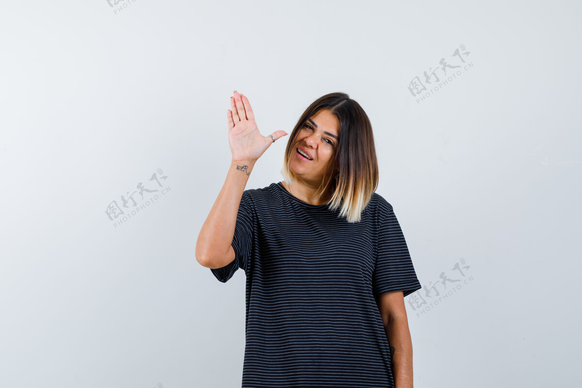手掌身着马球衫的年轻女士 展示手掌致意 看起来很欢快 正面视图模特年轻女士