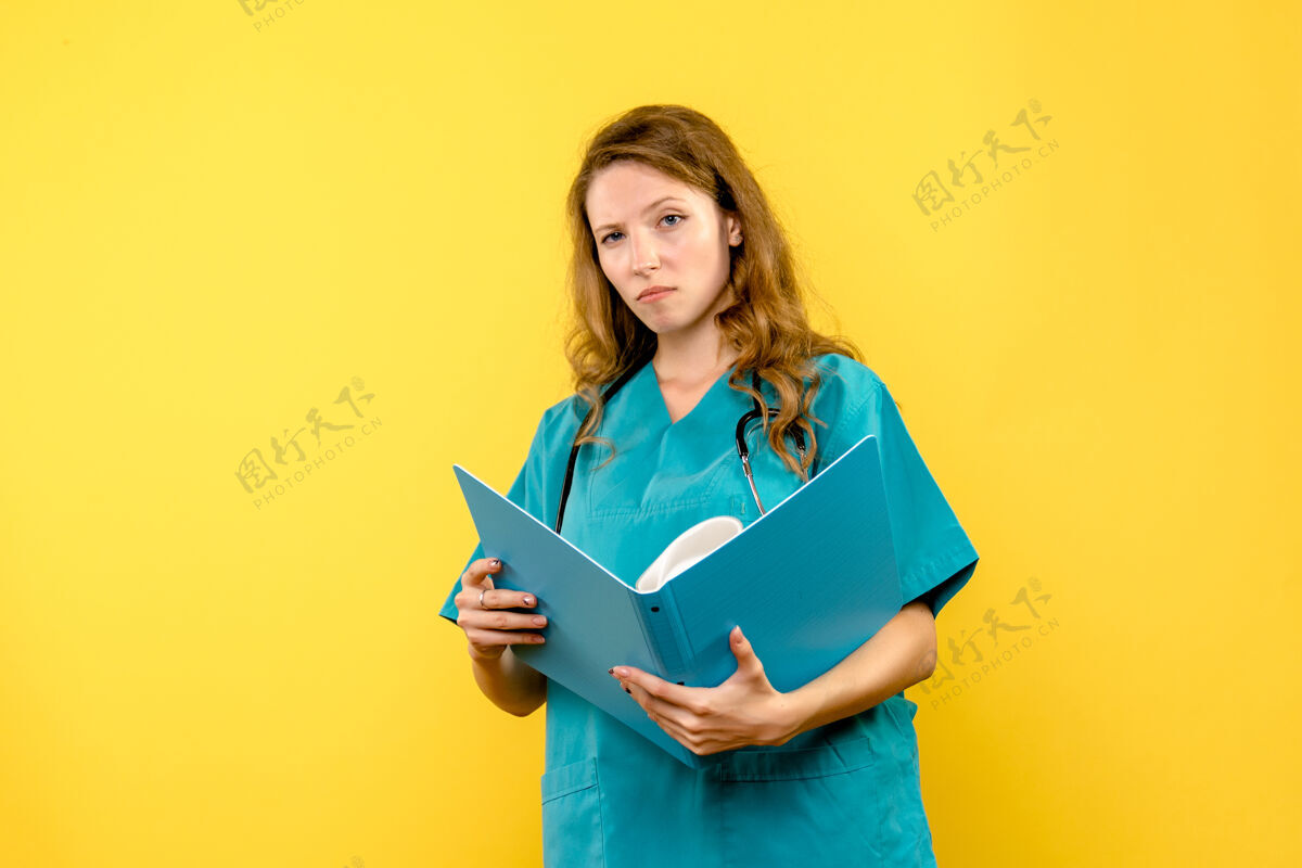 听诊器女医生看黄色墙上文件的正面图文件阅读成人