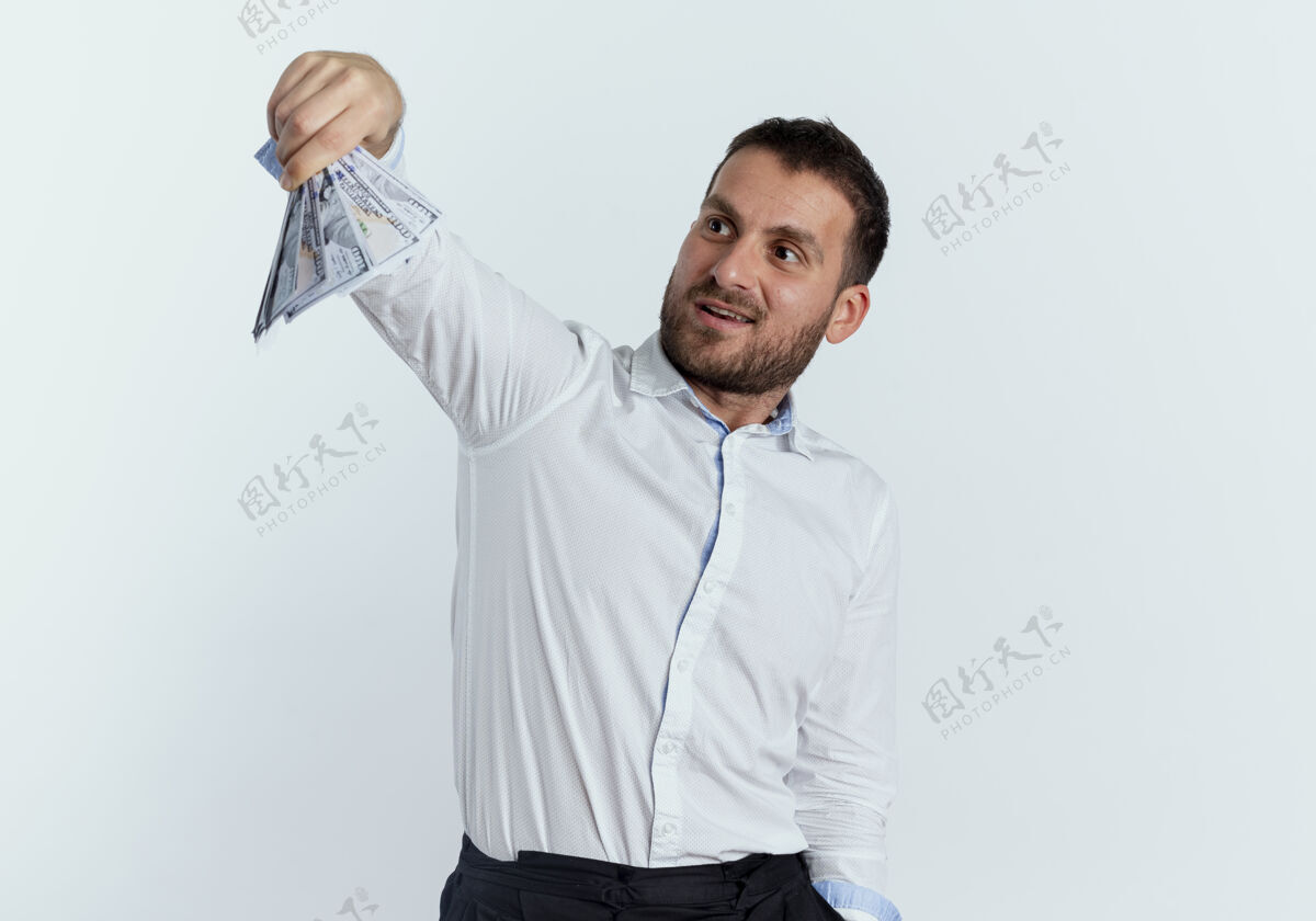 男人兴奋的帅哥抱着钱 看着隔离在白墙上的钱衬衫持有优雅