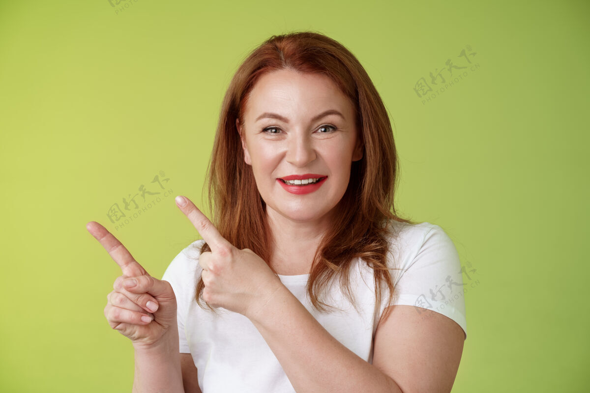 拇指特写快乐动机愉快红发中年女性指着左上角食指微笑快乐给出建议中年手势姜