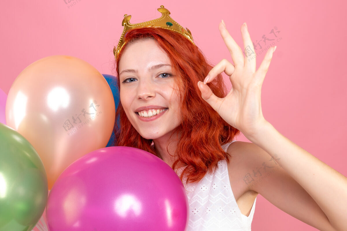 运动正面近距离观看手持粉色彩色气球的年轻女性人彩色前面
