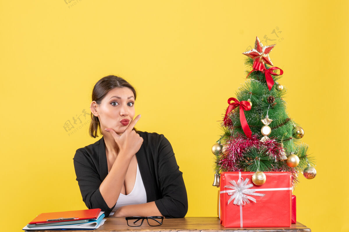 信心新年心情惊喜的年轻女子穿着西装 在黄色的办公室装饰圣诞树黄色执行心情