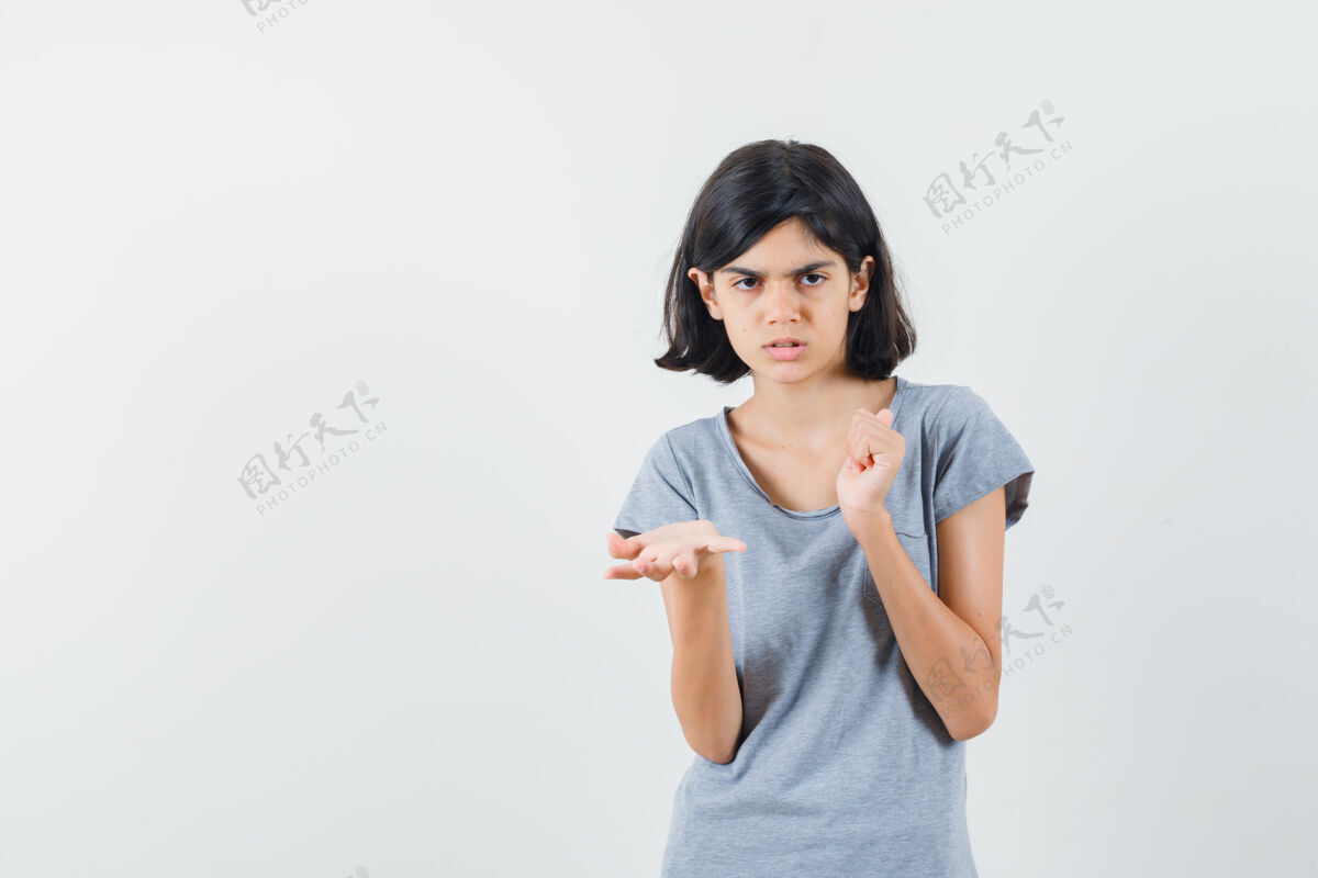 漂亮穿着t恤的小女孩摊开手掌 用拇指指了指后面 神情沉思 俯视前方孩子指着沉思