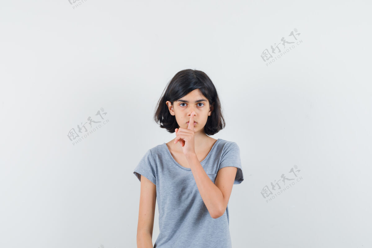 女性小女孩在t恤衫上显示出沉默的姿态 看上去很小心 正面视图表演人小